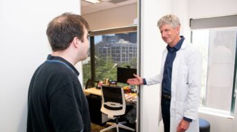 A doctor welcomes a person with intellectual disability to his office.