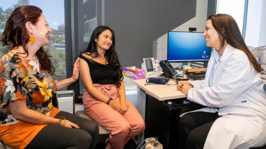 A person with intellectual disability speaking with a health professional and a supporter.