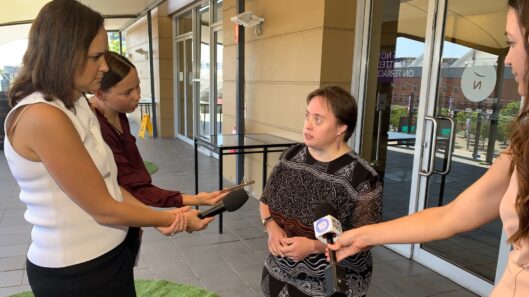 CID member Kylie Scott, a young woman with intellectual disability, is interviewed by the media outside of the Disability Royal Commission.