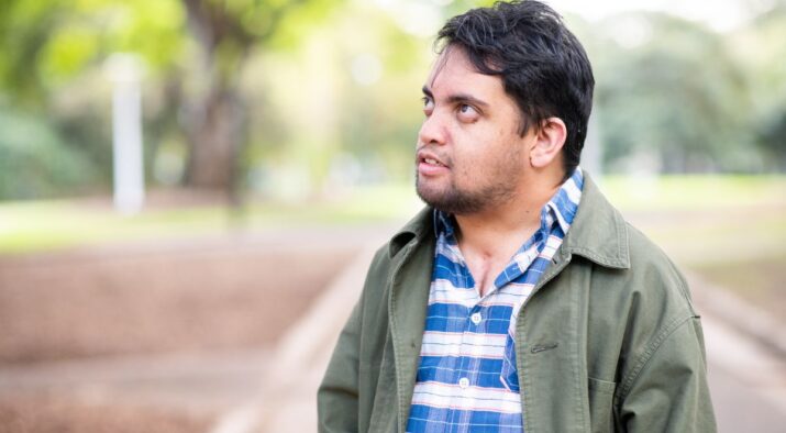 A young person with intellectual disability with a thoughtful look on his face.