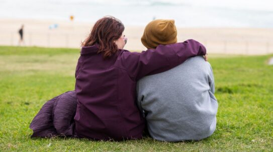 Two people with intellectual disability looking out at a beach.