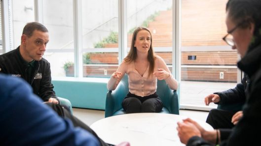A group of people with intellectual disability talk sitting around a table.