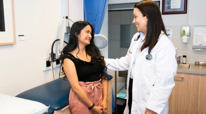 A woman with intellectual disability and a doctor smiling together in a doctor's office.