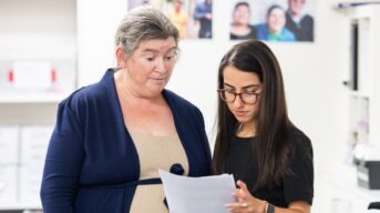 A support worker helping a person with intellectual disability understand a document