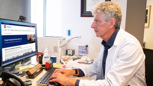 A doctor looking at the NSW government website for the single digital patient record